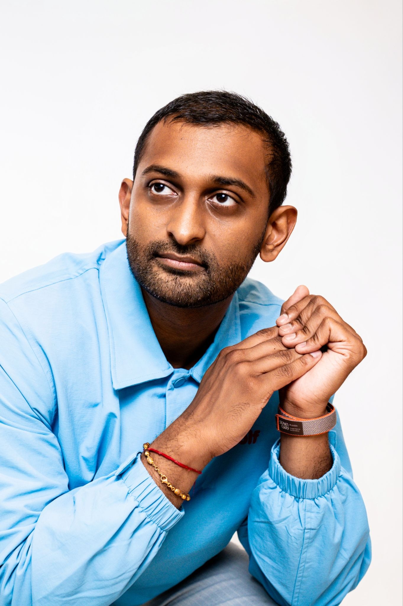 Dylan Patel in a blue shirt, with his hands clasped